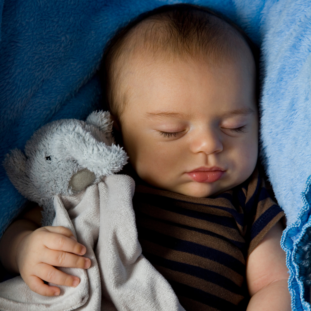 Bébé dormant paisiblement avec son doudou.